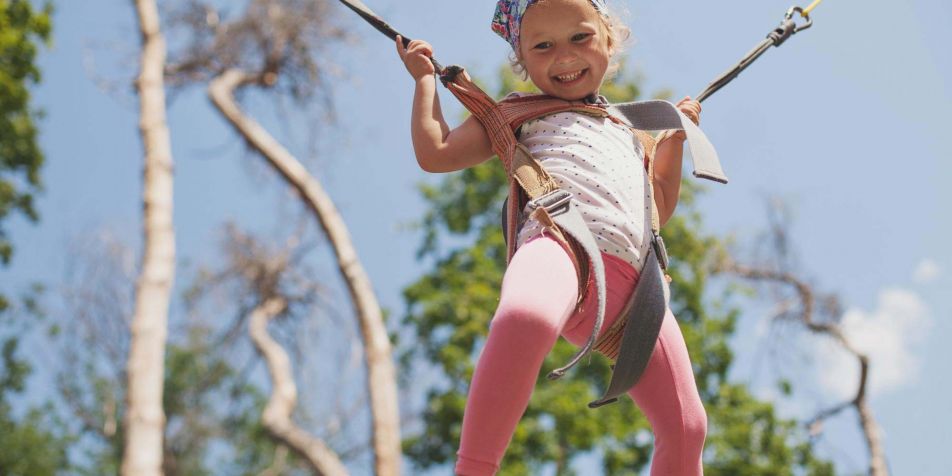 Mädchen springt mit dem Bungee-Trampolin im Kletterpark und Erlebnispark Riegersburg 
- 
Naturbursch Training Riegersburg - Teamtraining, Kletterkurse, Hochseilgarten