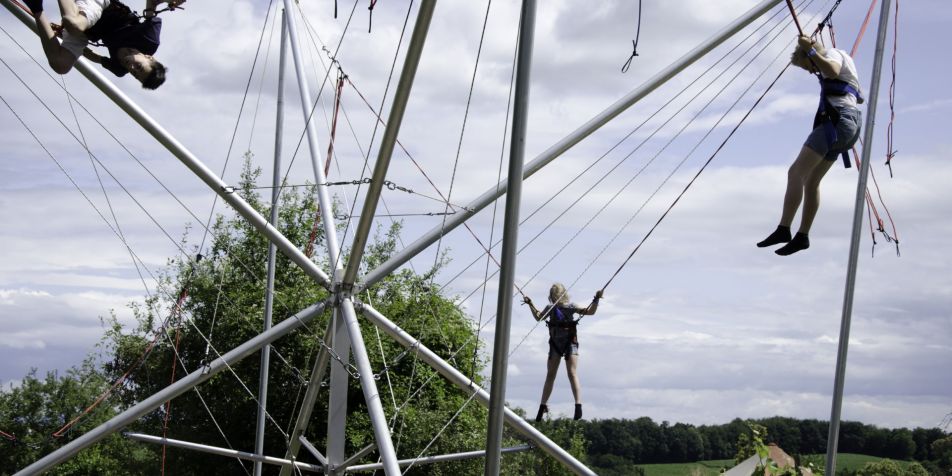Drei Kinder springen im Bungee-Trampolin 
- 
Naturbursch Training Riegersburg - Teamtraining, Kletterkurse, Hochseilgarten