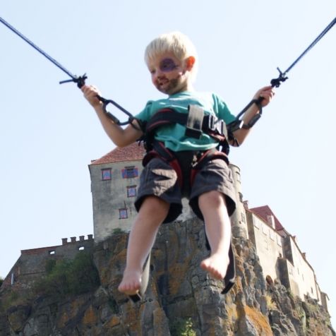 Kleiner Junge springt mit dem Bungee-Trampolin im Kletter- und Erlebnispark Riegersburg 
- 
Naturbursch Training Riegersburg - Teamtraining, Kletterkurse, Hochseilgarten