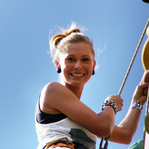 Junge Frau klettert eine 10 Meter hohe Kletterwand hoch 
- 
Naturbursch Training Riegersburg - Teamtraining, Kletterkurse, Hochseilgarten